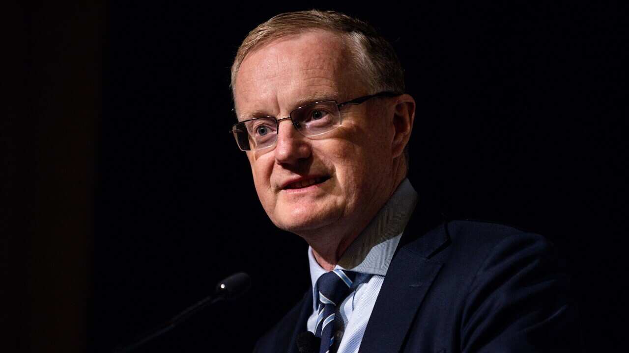 A man wearing a suit and tie who is speaking.