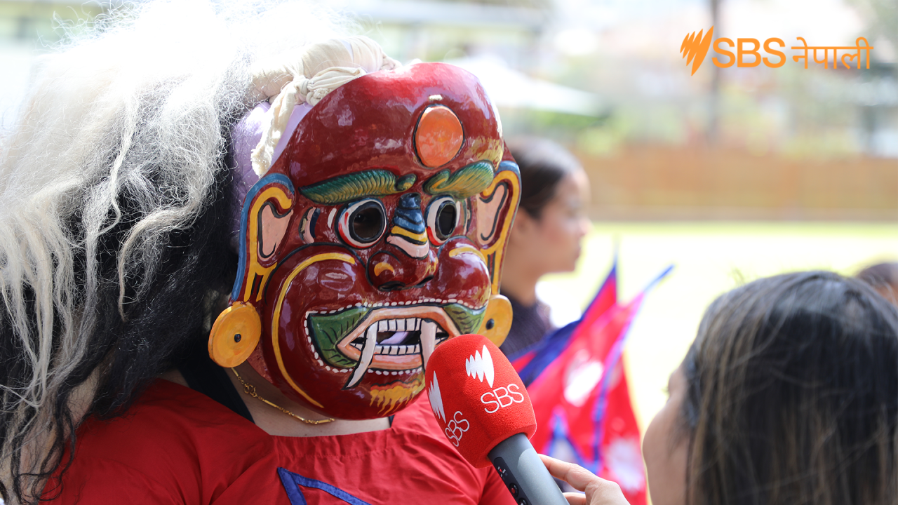 Man with a mask speaking to SBS Nepali during a community event in Sydney. Photo by Abhas Parajuli