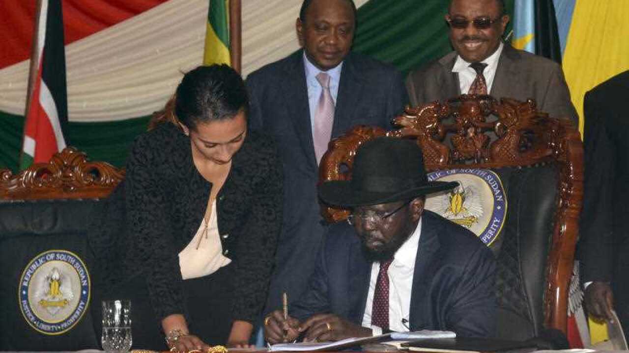South Sudan President Salva Kiir, seated, signs a peace deal, as Kenya’s President Uhuru Kenyatta, center, and Ethiopia’s Prime Minister Hailemariam Desalegn, right, witness the signing. (AAP)