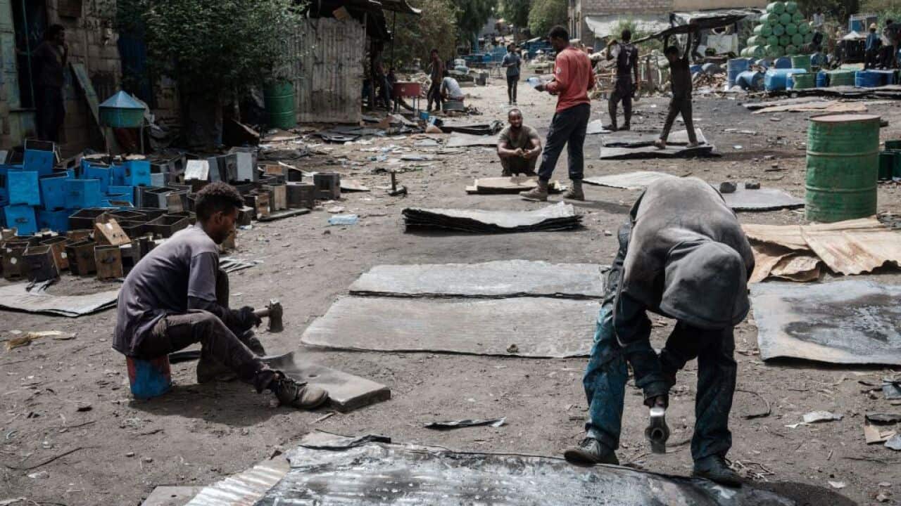 Craftsmen make metal sheets from oil drums on a street in Mekele, the capital of Tigray region, Ethiopia, on 25 June, 2021.
