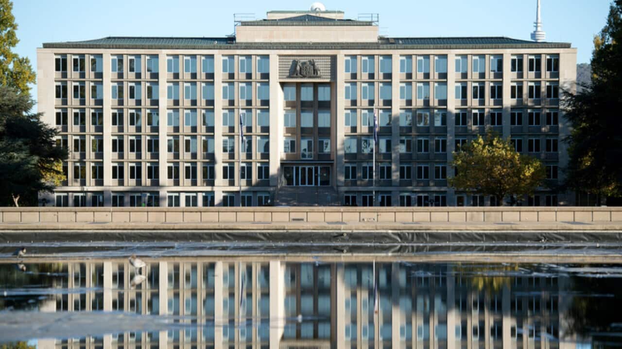 The Department of Treasury is seen reflected in a fountain in Canberra (AAP)