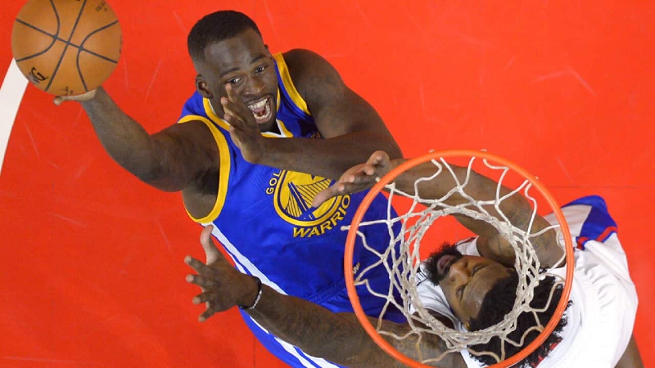 Golden State's Draymond Green (L) shoots