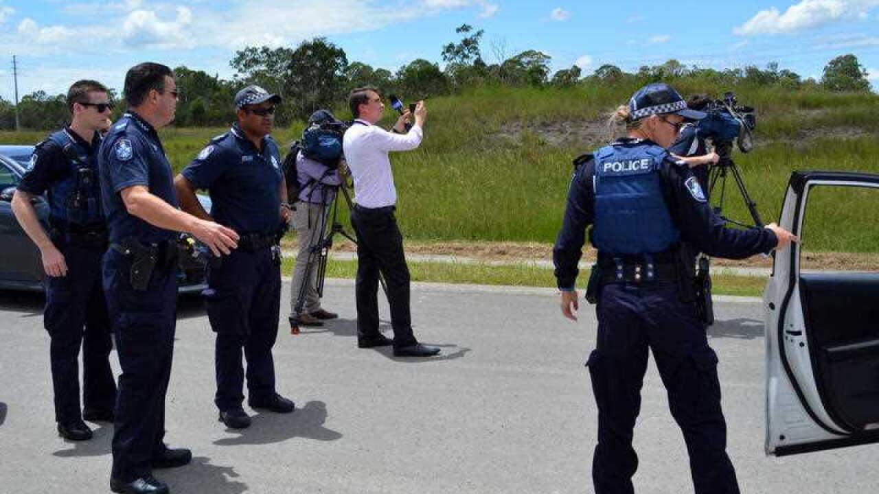 Police officers and members of the media at a crime scene near bushland in Kingston, south of Brisbane, Wednesday, Feb. 10, 2016.