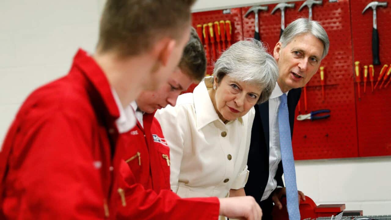 Prime Minister Theresa May and Chancellor Philip Hammond chat to apprentices during a visit to adi group, in Birmingham during the Conservative Party annual conference.
