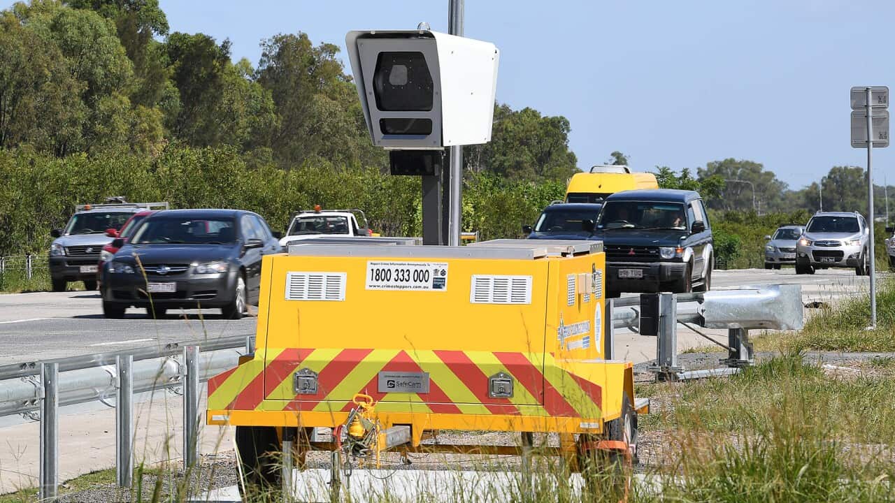 A speed camera on the side motorway with car passing by