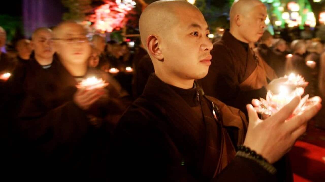 Buddhist monks hold candles during 'Transmission of Lamp'