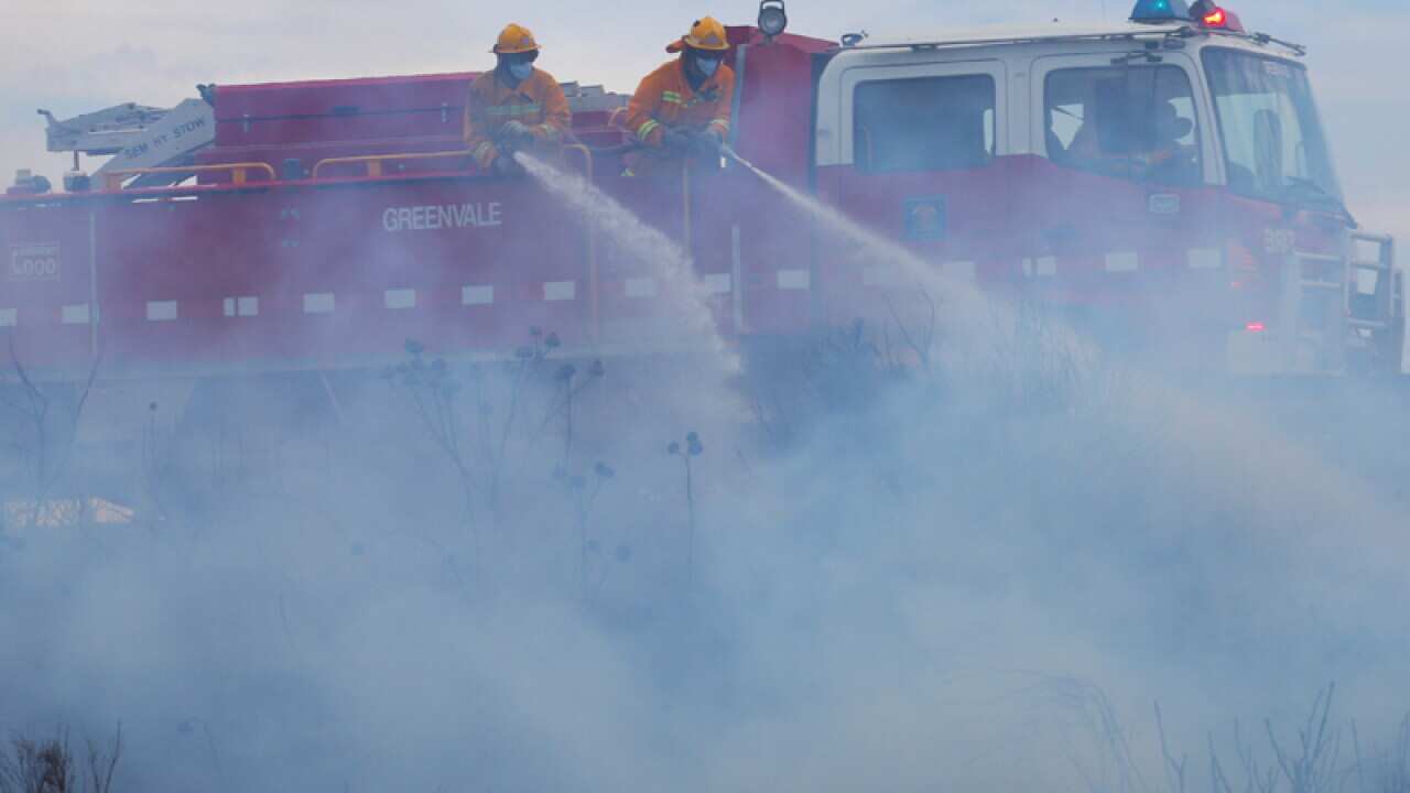 Firefighters battle a grass fire in the northern suburbs of Melbourne