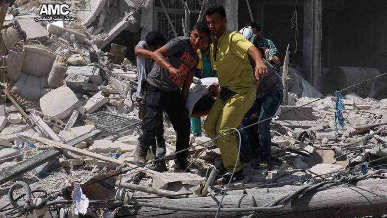 Syrians carrying a victim after barrel bombs were dropped on the Bab al-Nairab neighborhood in Aleppo