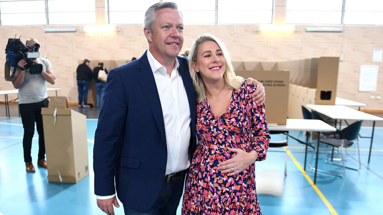 The Liberal MP for Fadden, Cameron Caldwell, poses with his wife next to a voting booth
