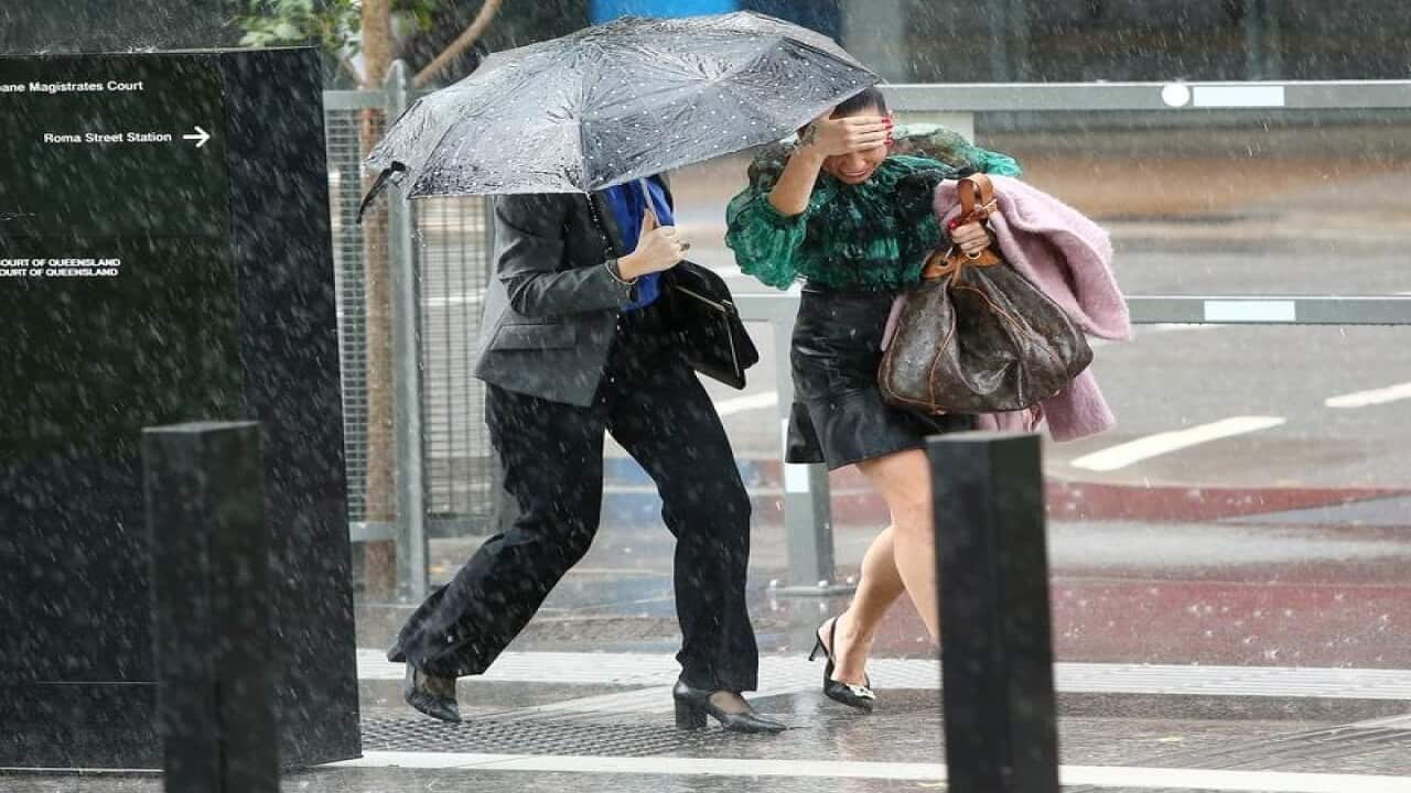 Pedestrians run through rain in Brisbane.