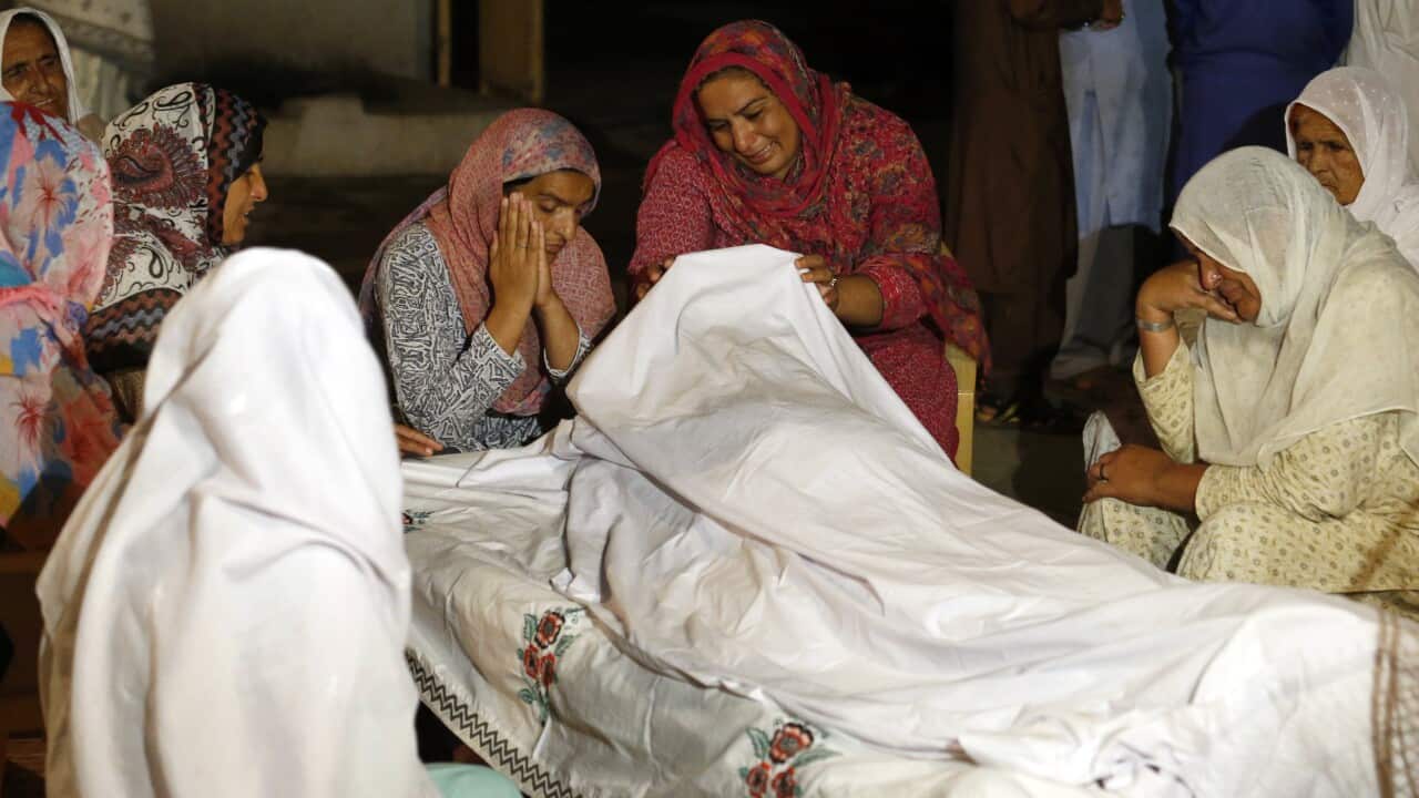 Women mourn beside the dead body of their family member Sabir Hussain, who died in a house collapse after a powerful earthquake struck in Sahang Kikri village near Mirpur, in northeast Pakistan, Tuesday, Sept. 24, 2019. (AP Photo/Anjum Naveed)