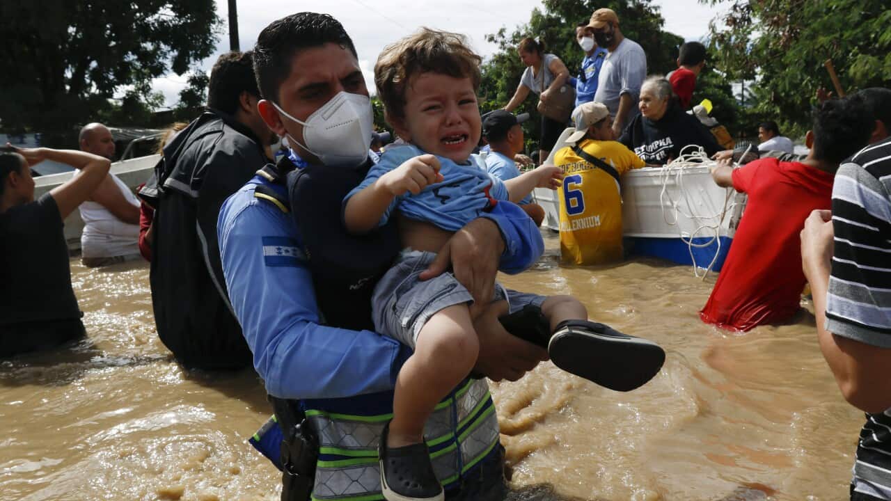 A boy is helped out of a flooded area in the neighbourhood of Jerusalen, Honduras, on 5 November.