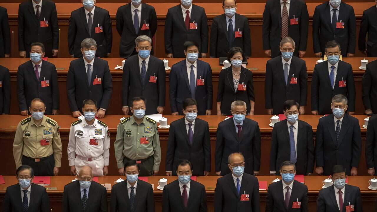 Delegates stand during the closing session of China's National People's Congress (NPC) in Beijing, Thursday, May 28, 2020.