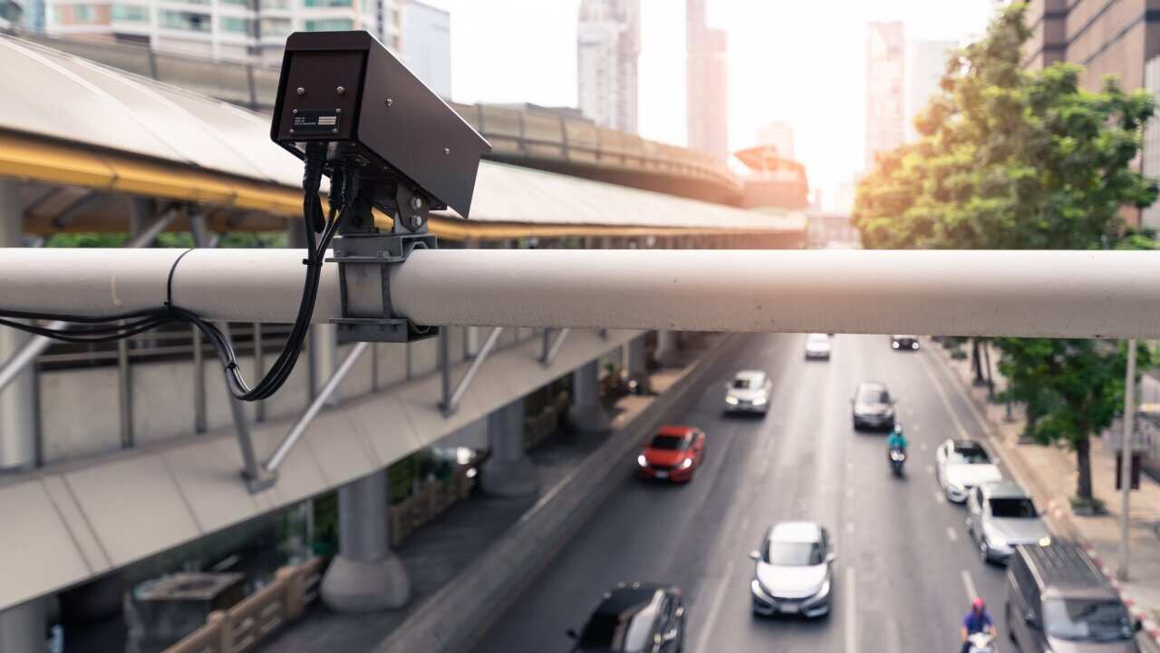 the closeup image of the security camera of cctv camera on the road which is broadcasting traffic situations. the concept of security, traffic, internet of things and transportations.