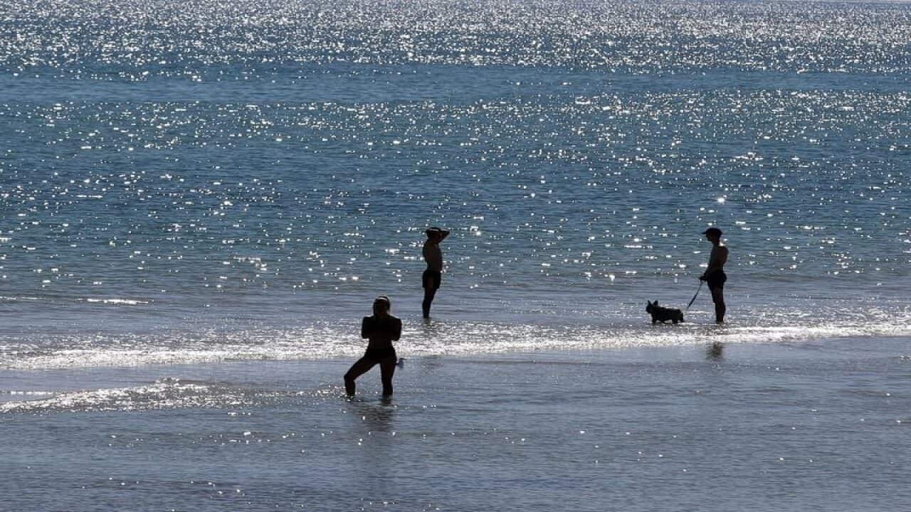 People are seen enjoying the hot weather on Henley Beach in Adelaide