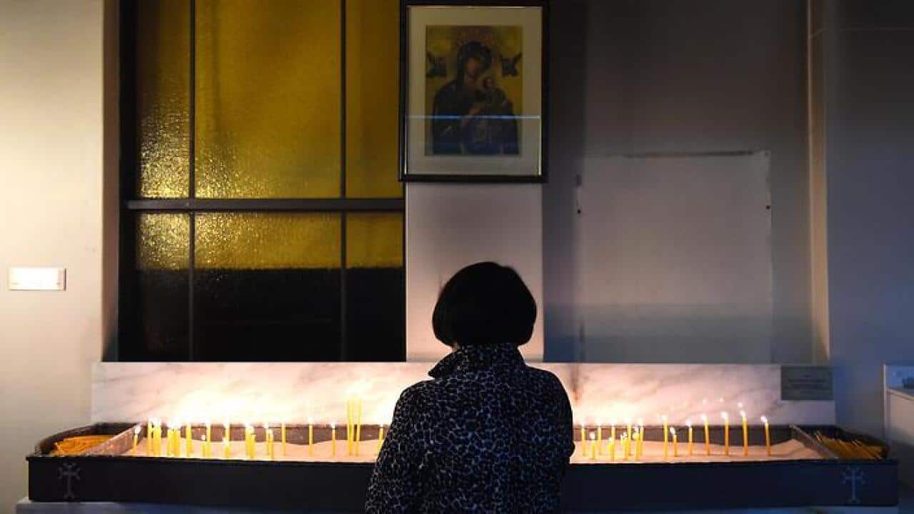 A worshipper lights a candle at the Armenian Apostolic Church of Holy Resurrection in Sydney.