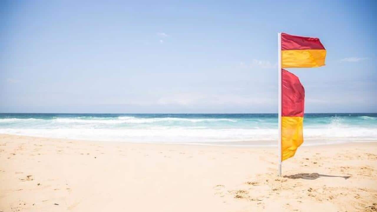 Swim between 2 red-and-yellow flags at the beach