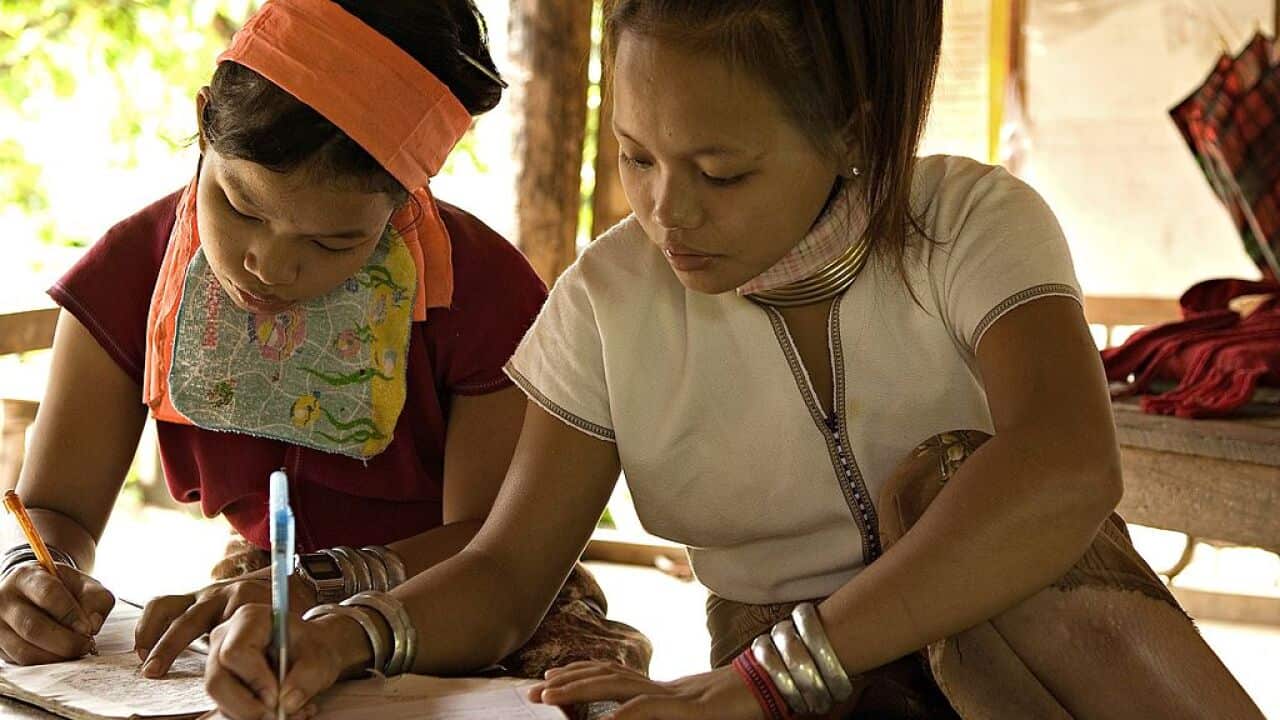 Young "long neck" women attend a school class in Huay Pu