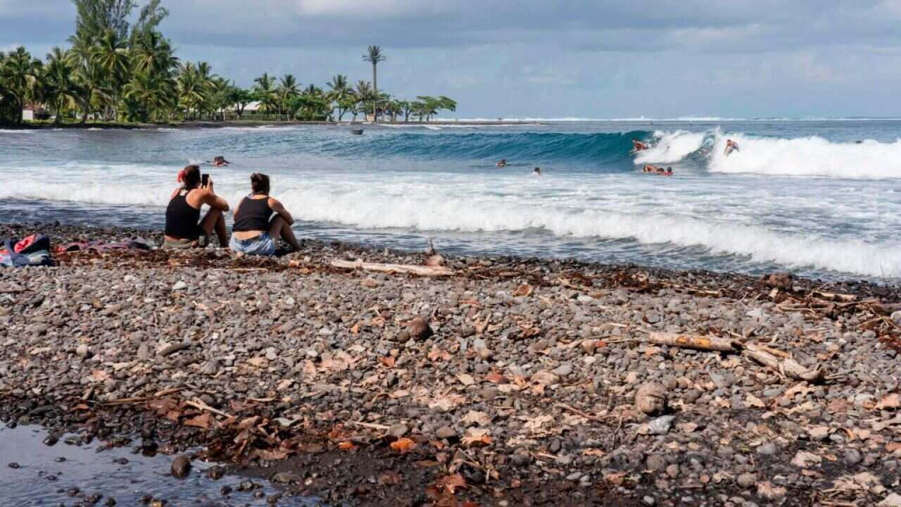 People on the beach of Teahupoo, southwestern coast of Tahiti, French Polynesia.