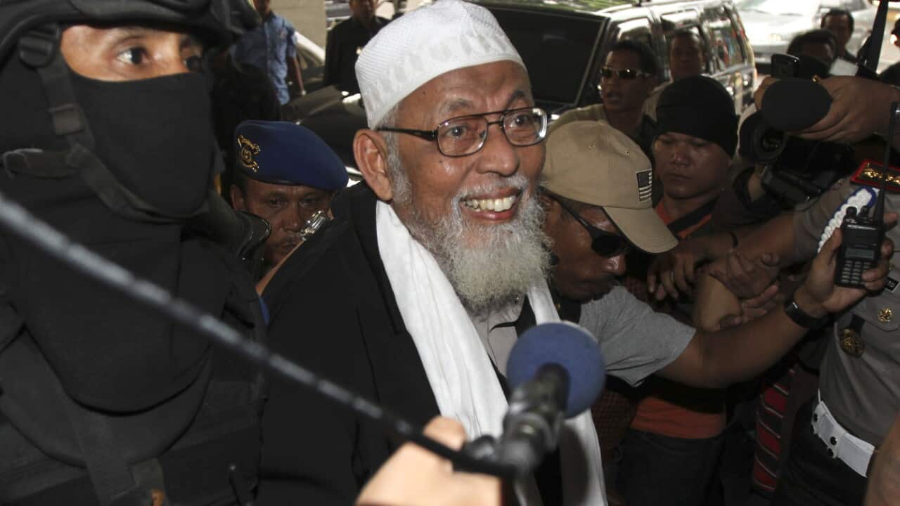 Radical Indonesian cleric Abu Bakar Bashir, center, escorted by Indonesian police as he arrive at Indonesian police headquaters in Jakarta, Indonesia, Monday, Aug 9, 2010. (AP Photo/Irwin Ferdiansyah)