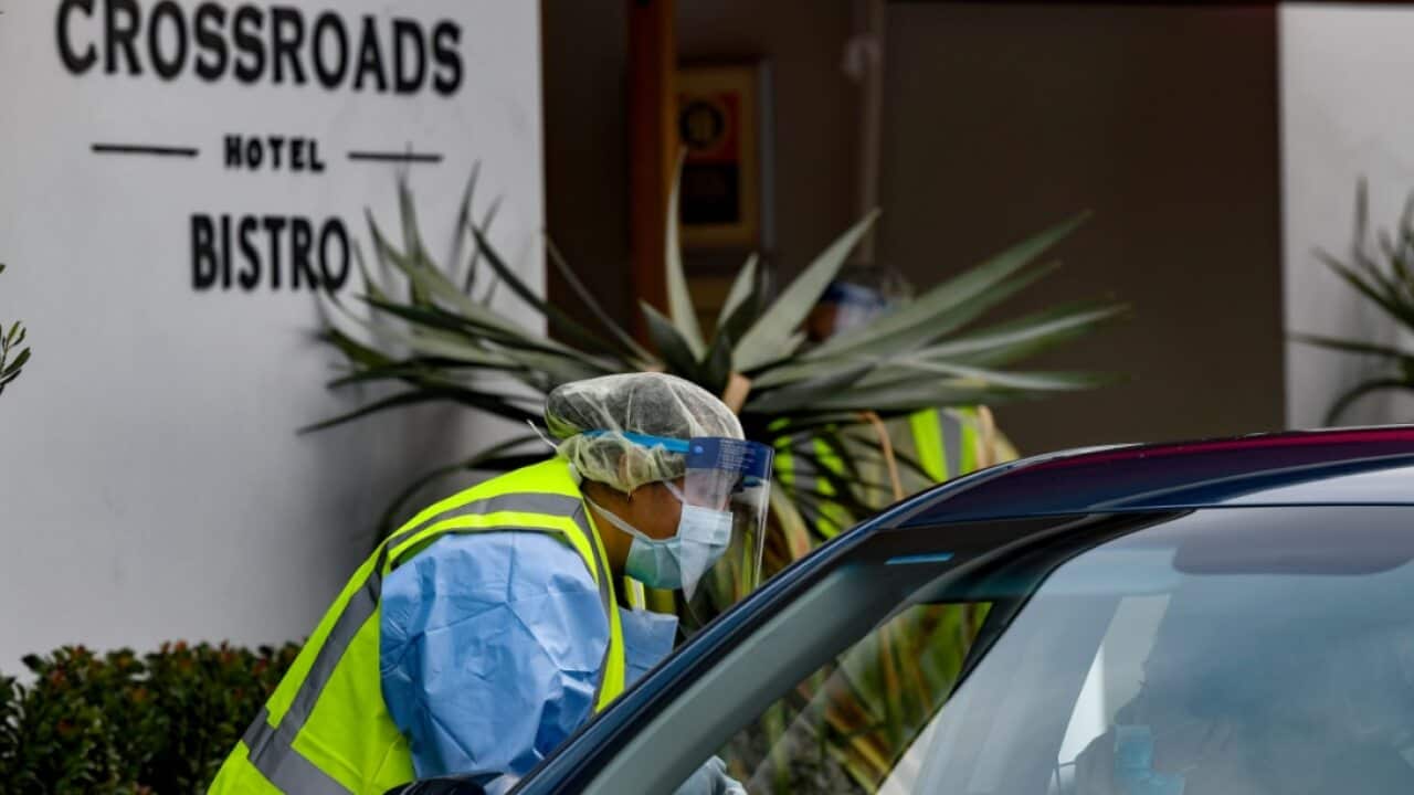 Workers administering COVID-19 tests to people in their cars at the Crossroads Hotel testing centre in Sydney, Saturday, July 11, 2020