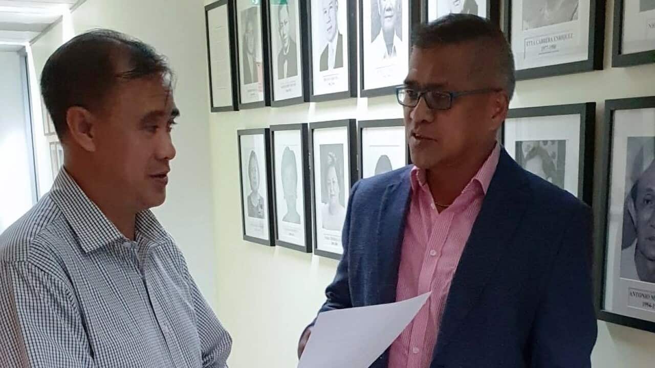 Alric Bulseco, right, in a discussion with a Consular officer