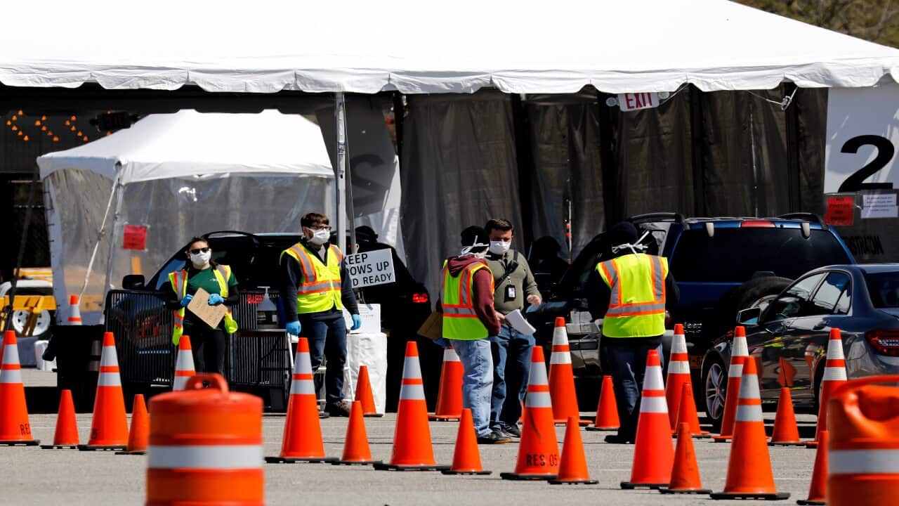 Workers direct people queueing up in theirs cars waiting to be tested for coronavirus COVID-19 at the drive-in test site in New York.