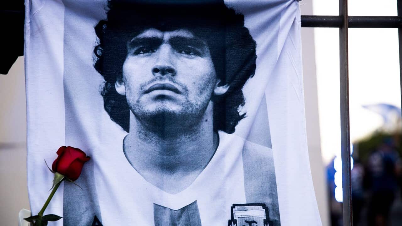 A shirt with an image of Diego Maradona on a fence in Buenos Aires, Argentina