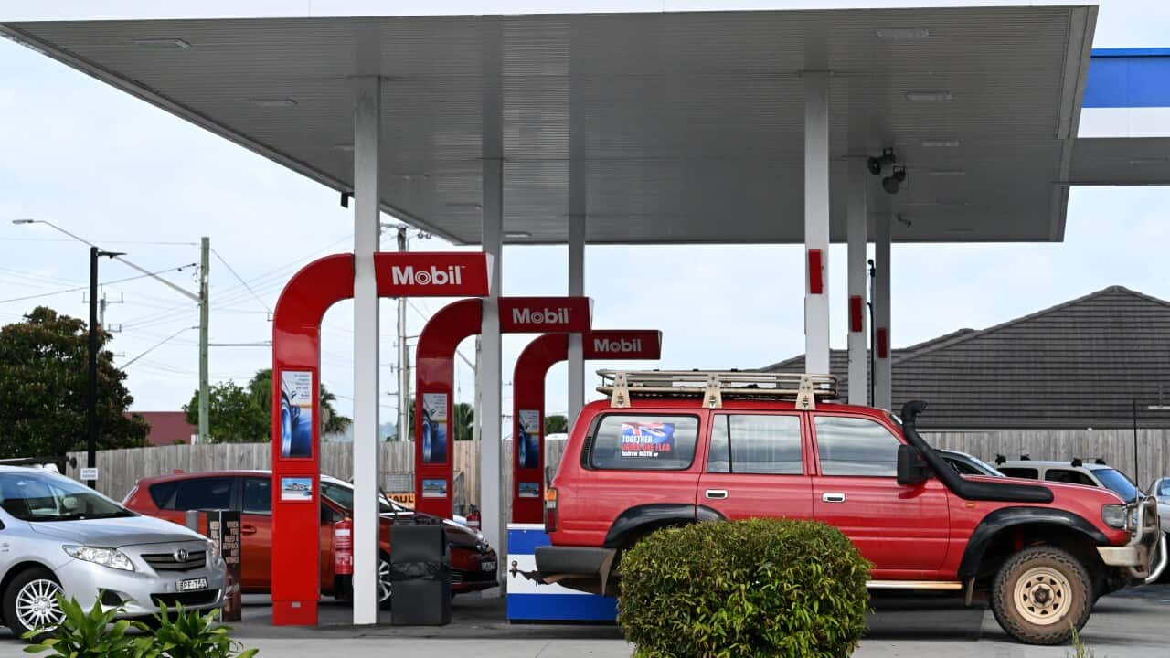 Cars line up to purchase fuel at a service station.