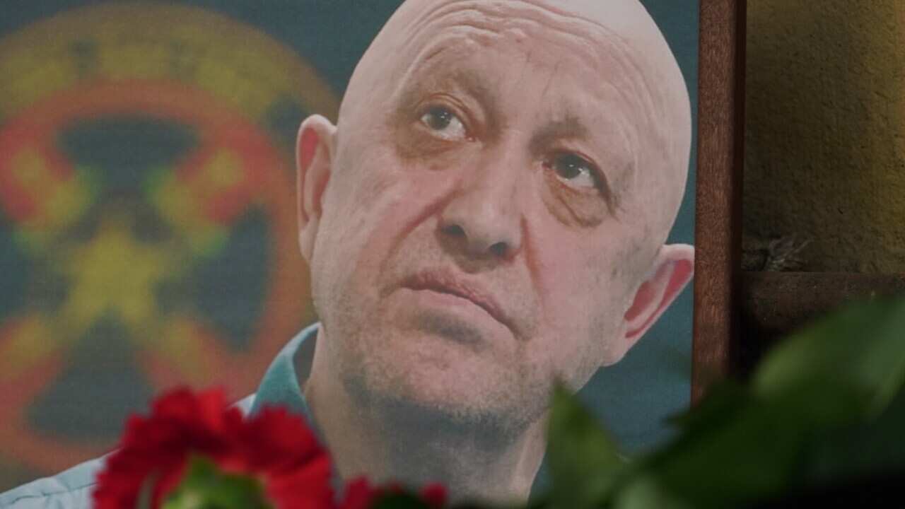 Flowers placed in front of a photo of a man.