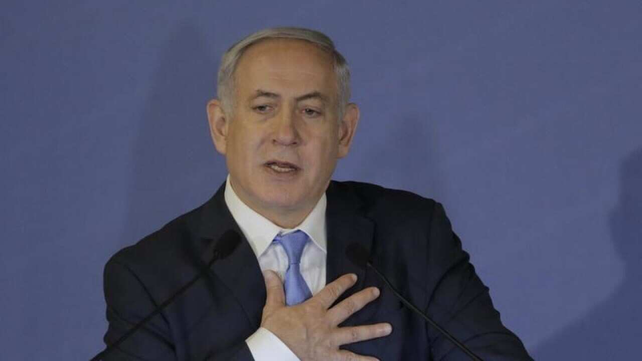 Israeli PM Benjamin Netanyahu touches his chest as he speaks.