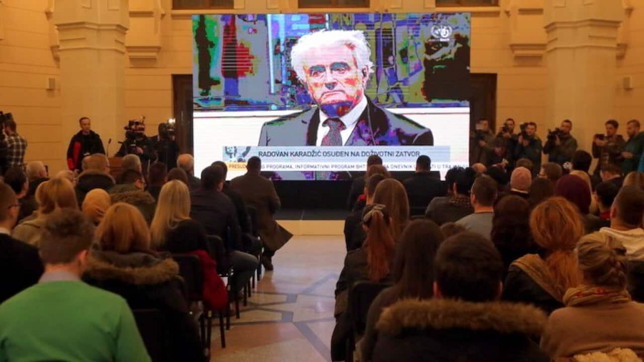 People watch a TV relay of the trial of war-time Bosnian Serb leader Radovan Karadzic in Sarajevo, Bosnia.