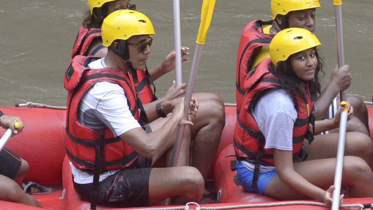 Former U.S. President Barack Obama, left, his wife Michelle, center rear, and daughter Sasha, right, raft on Ayung River in Badung, Bali island, Indonesia
