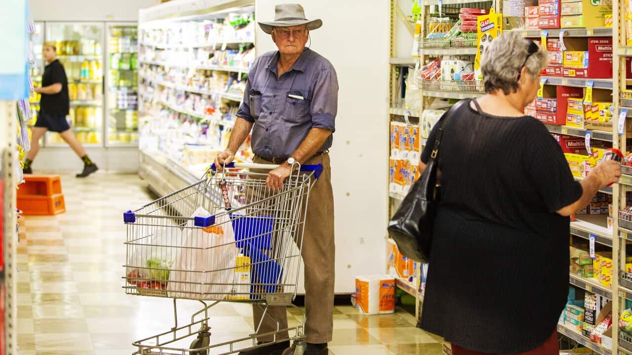 Elder couple stand in aisle at supermarket