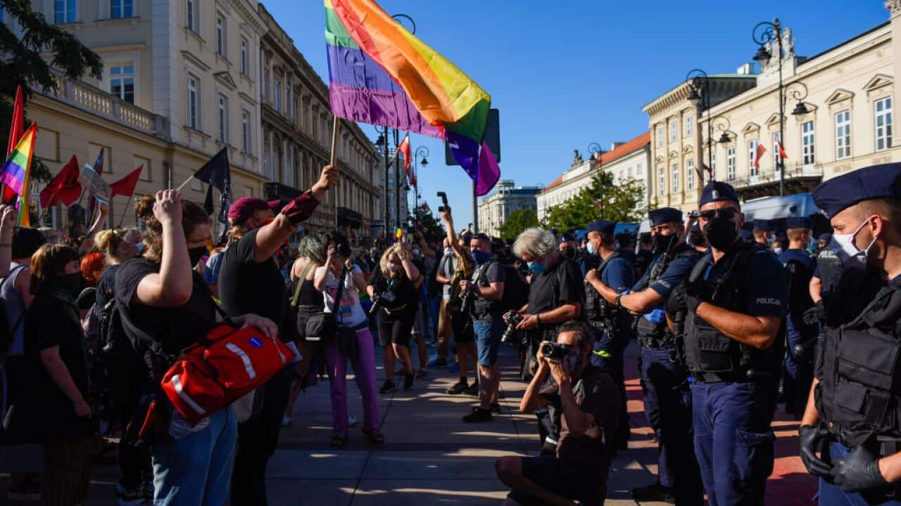 LGBTIQ+ activists hold banners during a counter protest against an anti-LGBTIQ+ far right rally in Warsaw.