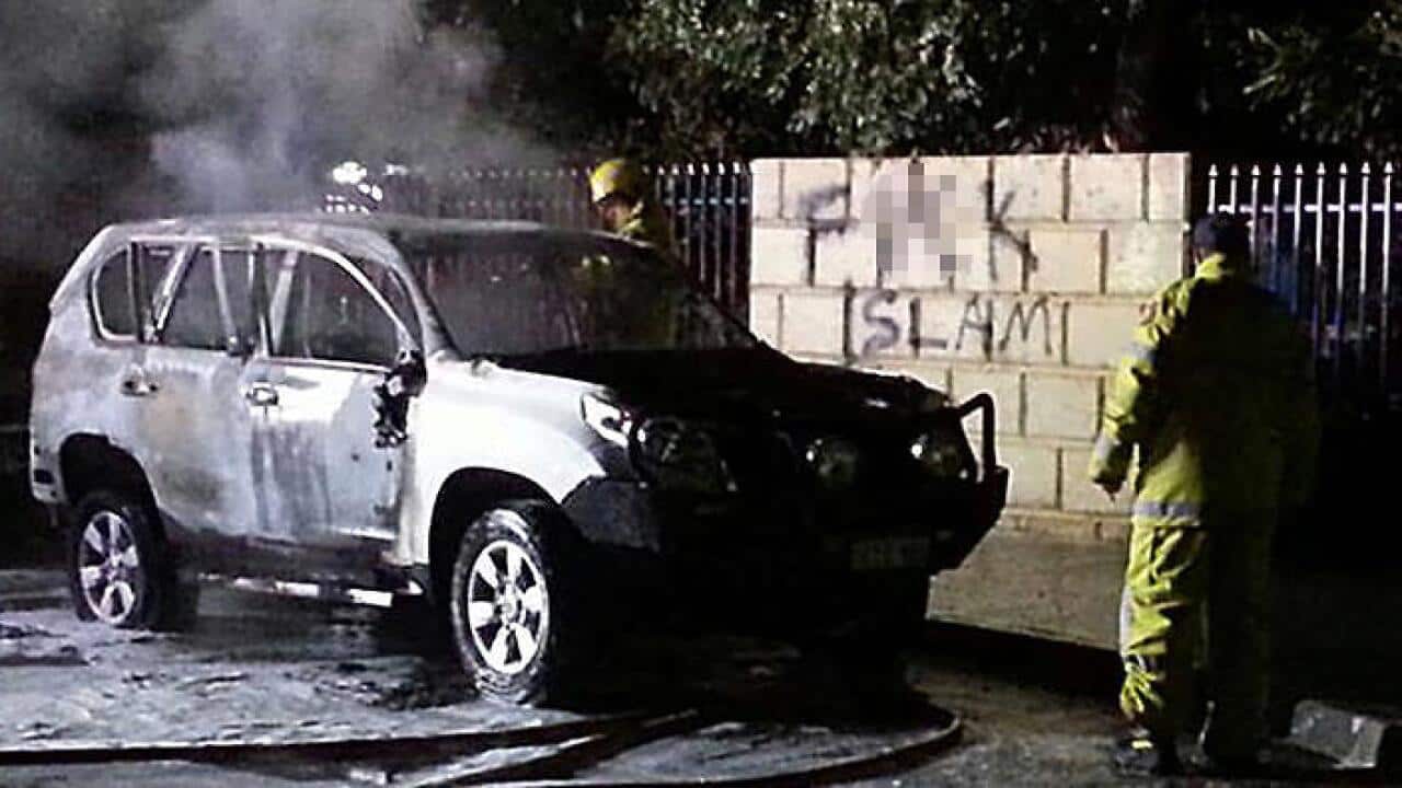 Anti-Islamic graffiti and a burnt out car seen outside the Thornlie Mosque, Perth, Wednesday, June, 29, 2016. 