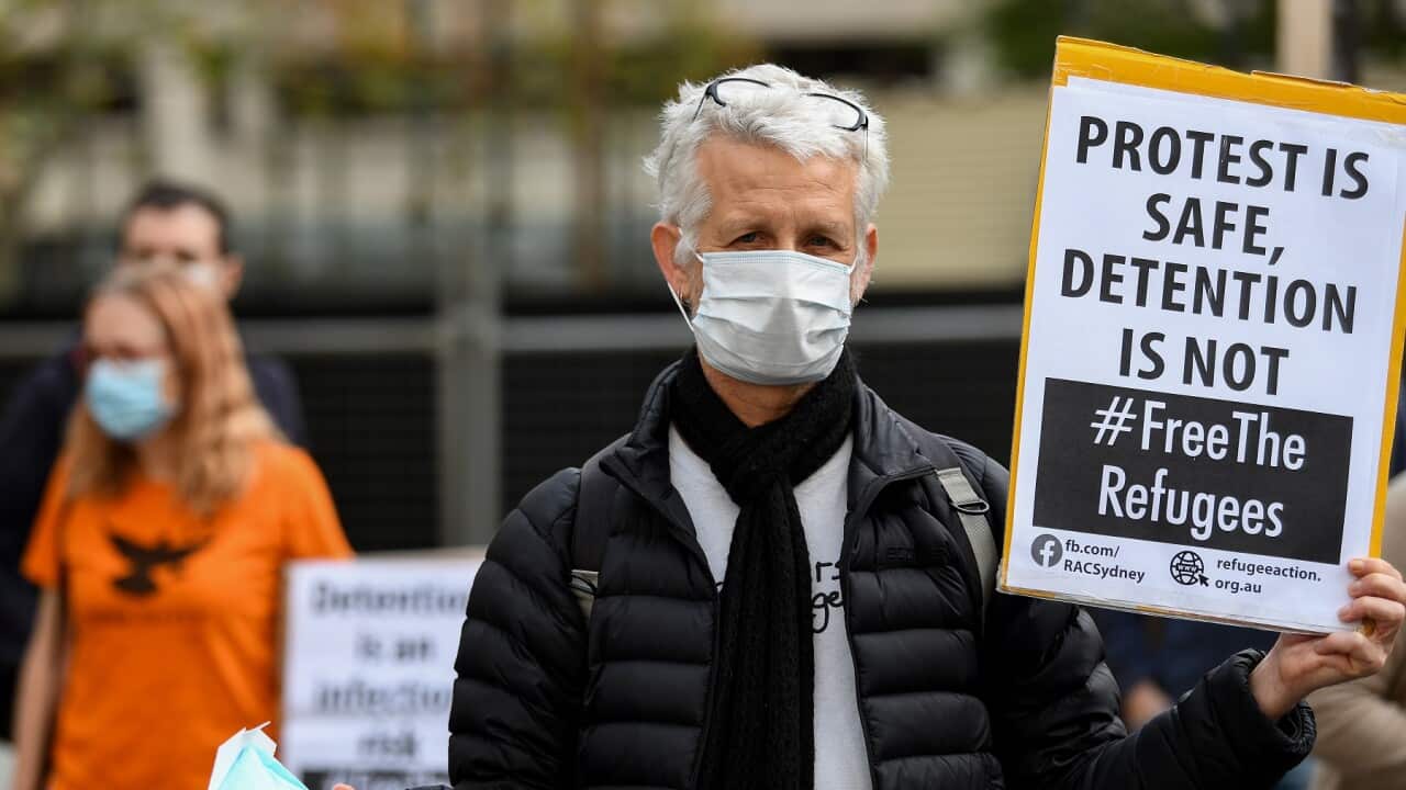 Protesters hold placards during a "Free The Refugees" rally at Sydney Town Hall in Sydney, Saturday, June 13, 2020. The Supreme Court on Thursday prohibited the protest from going ahead. (AAP Image/Bianca De Marchi) NO ARCHIVING