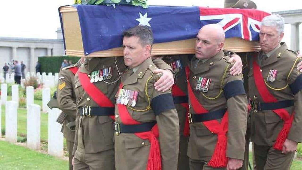 Soldiers carry a coffin containing the remains of an unknown World War I digger