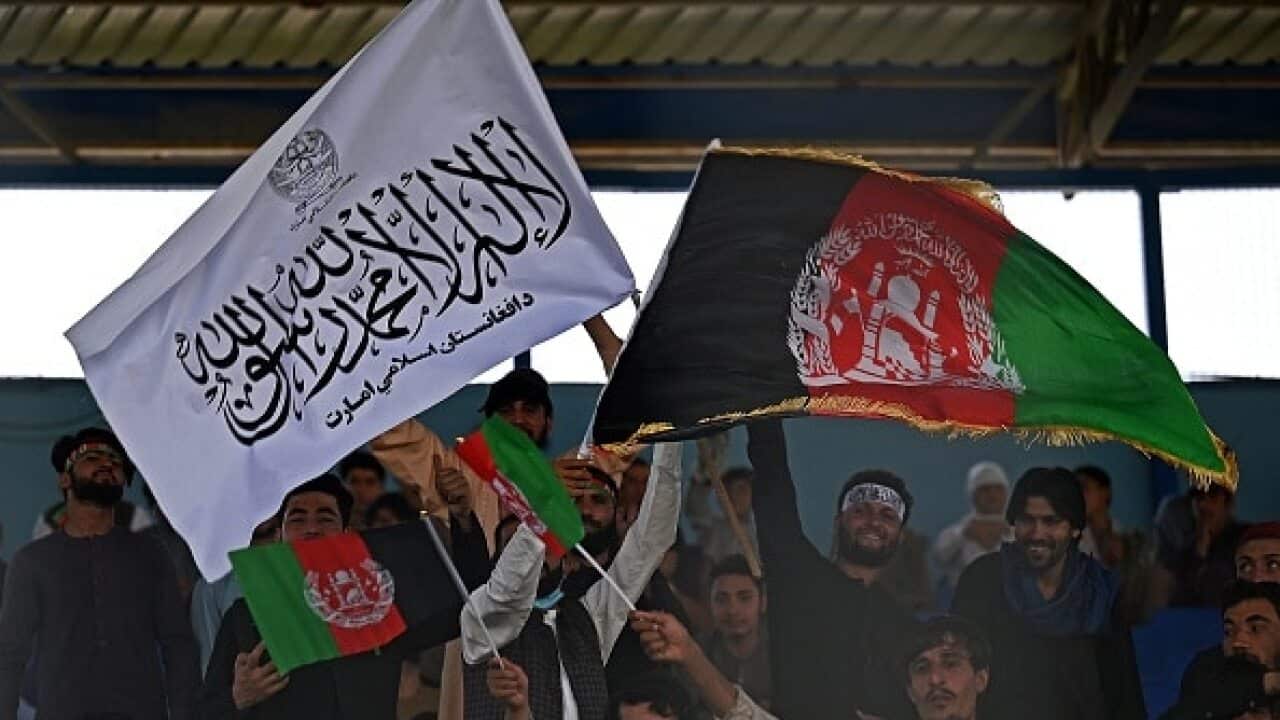 Spectators wave Afghanistan's and Taliban flags as they watch a Twenty20 cricket match in Kabul on 4 September 2021.