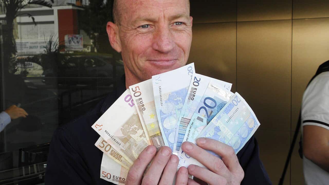 A man with the money he got from Laiki Bank branch in Limassol, Cyprus