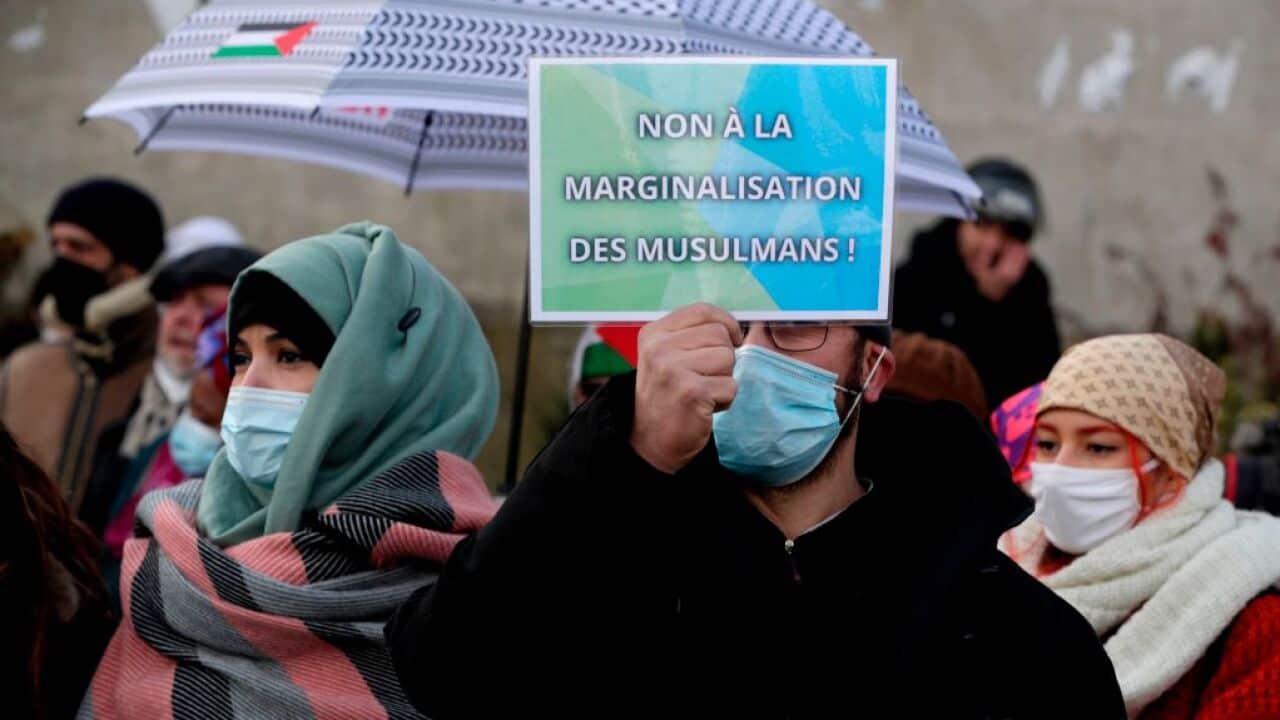 A man holds a placard in support of France's Muslim community during a protest against the 'anti-separatism' bill in Paris on February 14, 2021