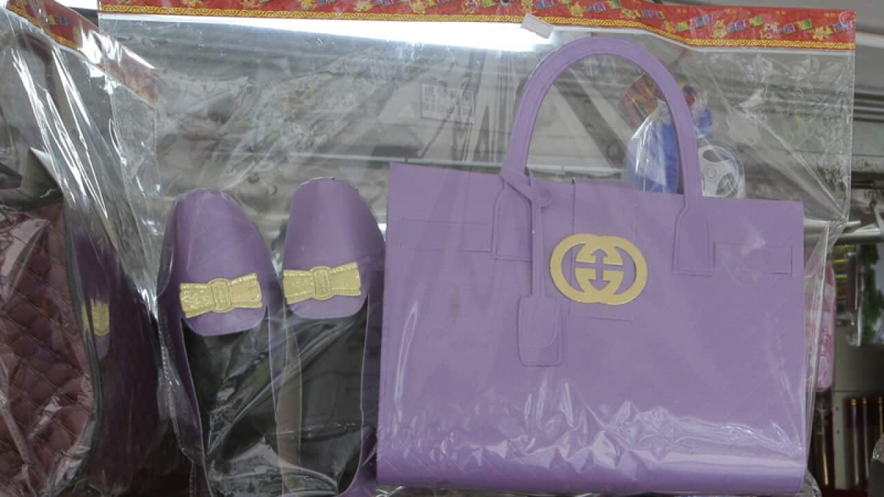 Paper offerings featuring a pair of shoes and a handbag at a store