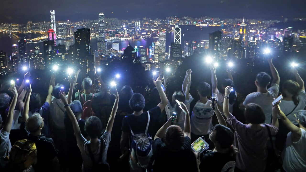 Demonstrators hold up their mobile phone lights to form a human chain at the Peak, a tourist spot in Hong Kong.