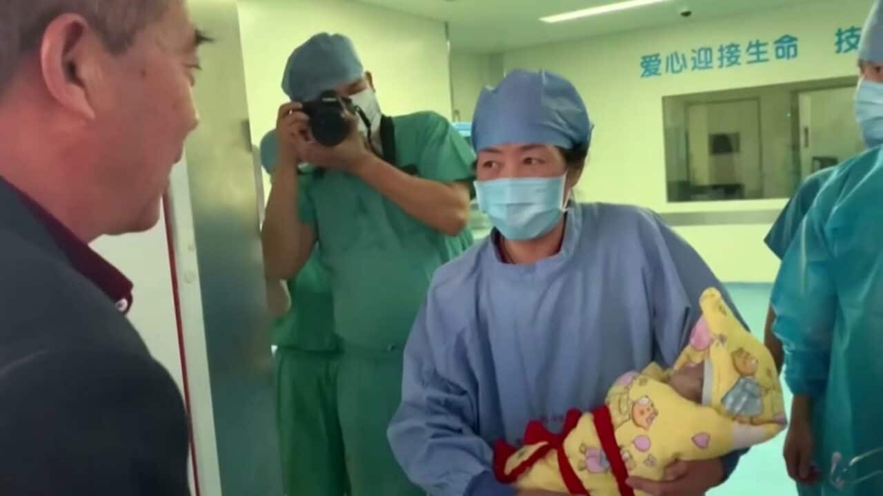 A midwife holding the baby