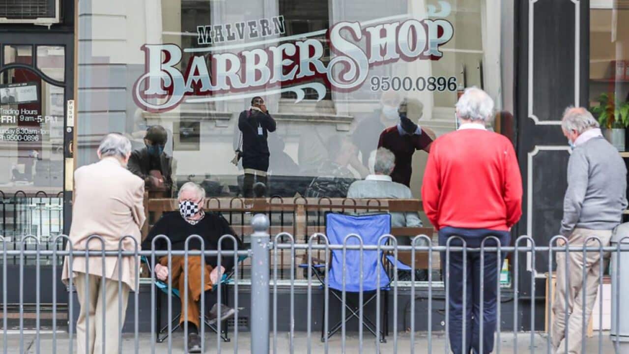 A group of men are seen lined up outside a barbershop as they wait to get their haircut on 19 October, 2020 in Melbourne.