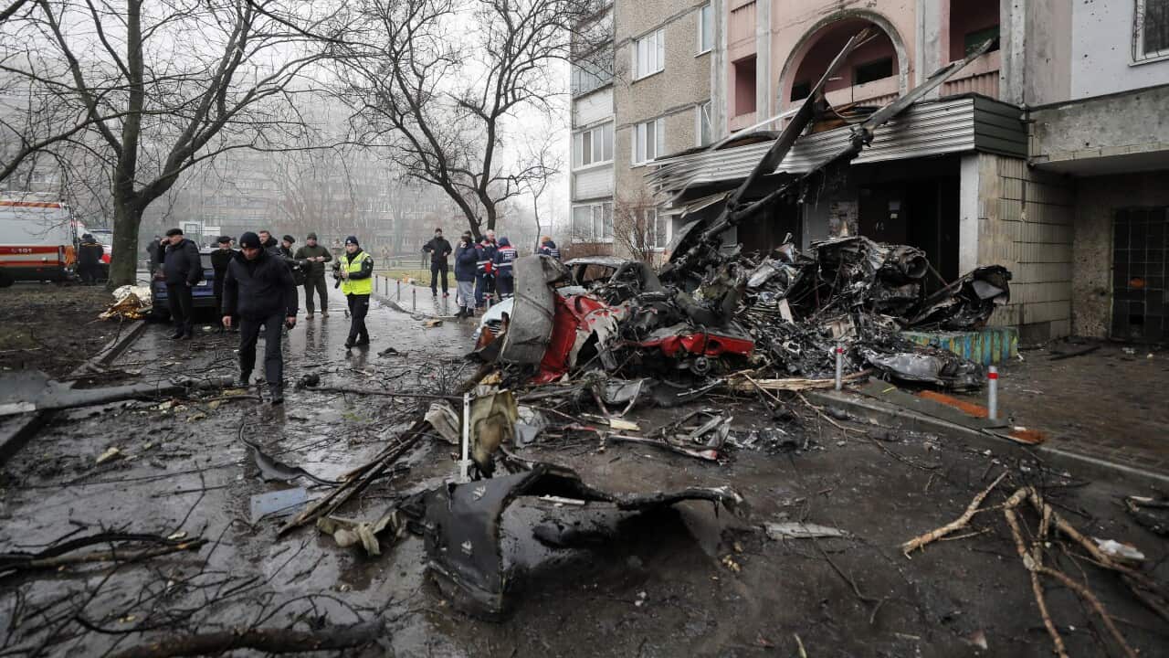 Rescue services work at the scene of a helicopter crash near the wreckage in Brovary, near Kyiv, Ukraine, 18 January 2023.