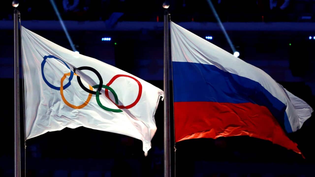 The Olympic flag flies next to the Russian flag