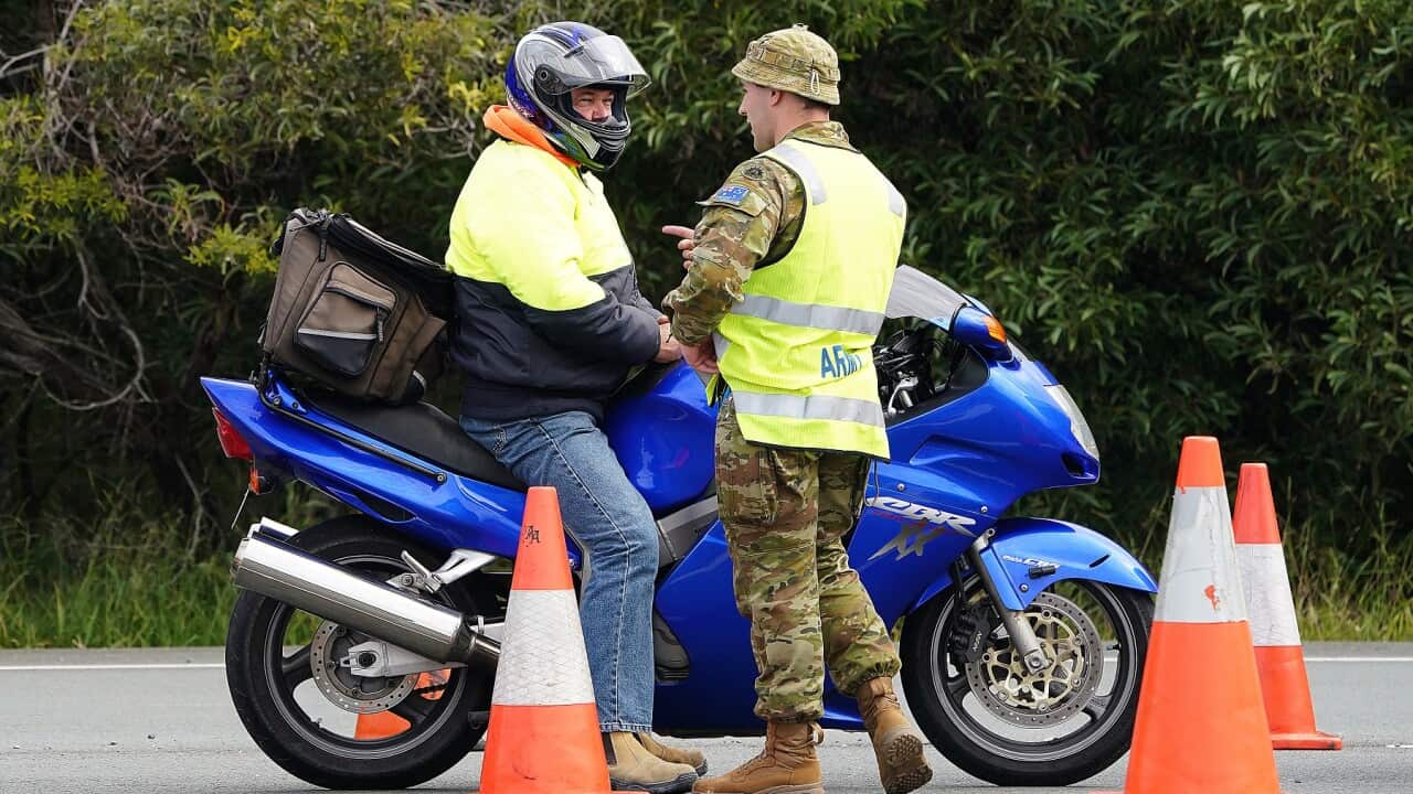 A motorcyclist is stopped at a checkpoint at Coolangatta on the Queensland- New South Wales border.