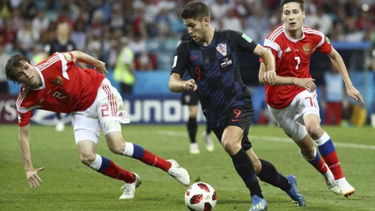 Croatia's Andrej KRAMARIC and Russia's Daler KUZIAEV struggle to hold a ball in the second half during the match of the Quarter-finals in FIFA World Cup.