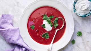 vibrantly red beetroot and kimchi soup in a pale bowl